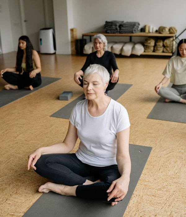 A group of diverse people sitting calmly after a yoga class, all with a light sepia filter.